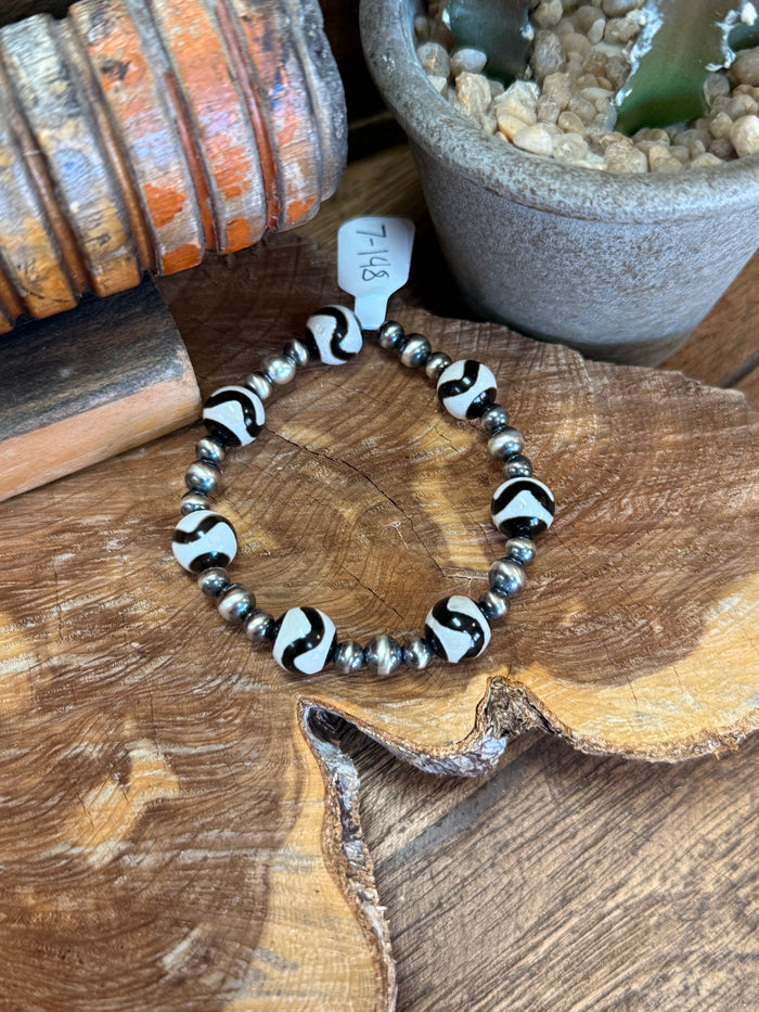 Silver spacer bead stretch bracelet with black-and-white swirl accent beads