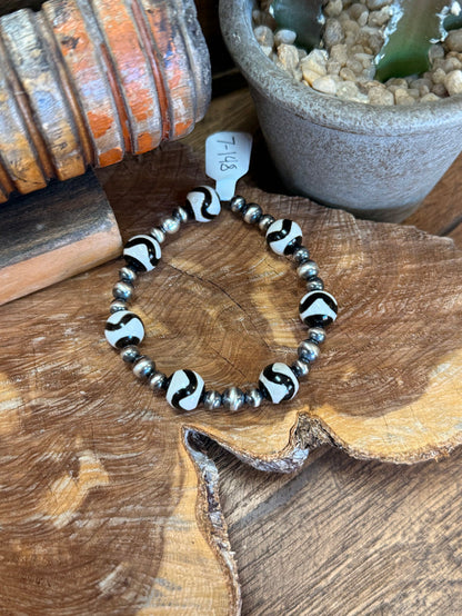 Silver spacer bead stretch bracelet with black-and-white swirl accent beads