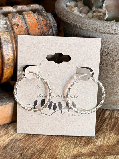 Large twisted-rope round hoop earrings with dangling clasp, shown on product card