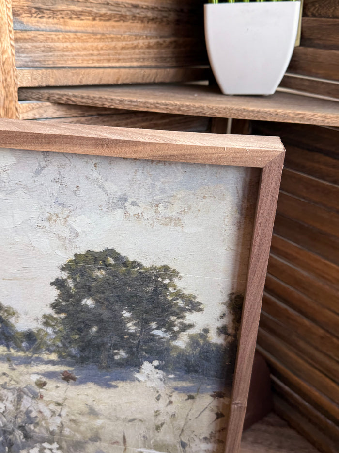 Framed prairie landscape artwork corner with wooden frame and wildflower details