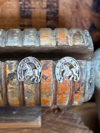 Silver-tone horse in horseshoe stud earrings with textured bead edge detail.