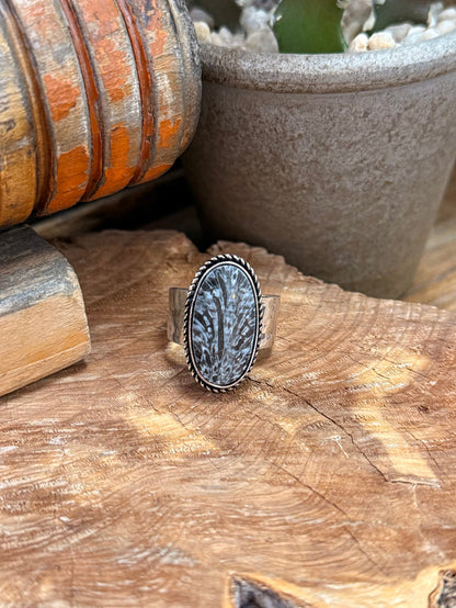 Adjustable oval fossil stone ring with silver-tone bezel and textured dark center