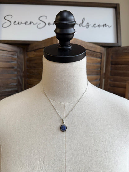 Round lapis-blue pendant necklace on mannequin, silver chain and bezel setting