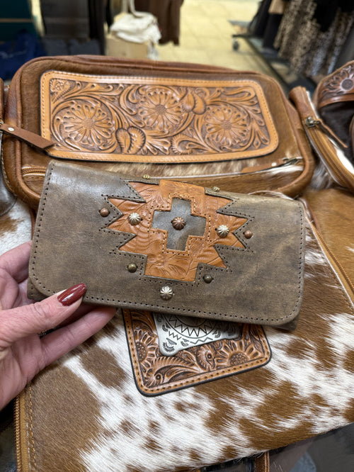 Hand-tooled leather wallet with studded cross design and snap closure