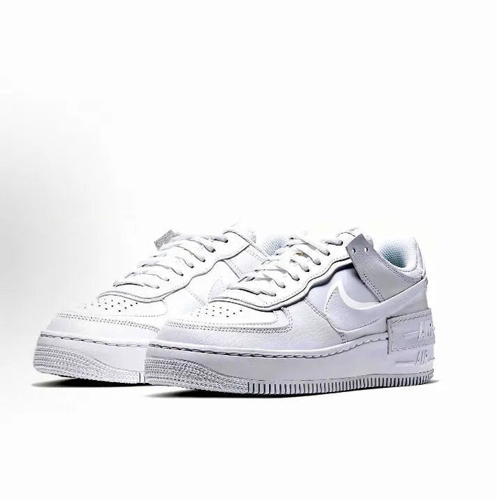 White low-top leather sneakers, front view with lace-up and side Nike Swoosh, rubber sole
