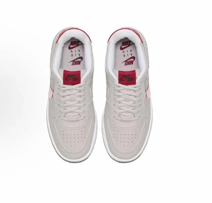 Nike low-top sneakers, light gray uppers with red tongues and red Nike heel branding