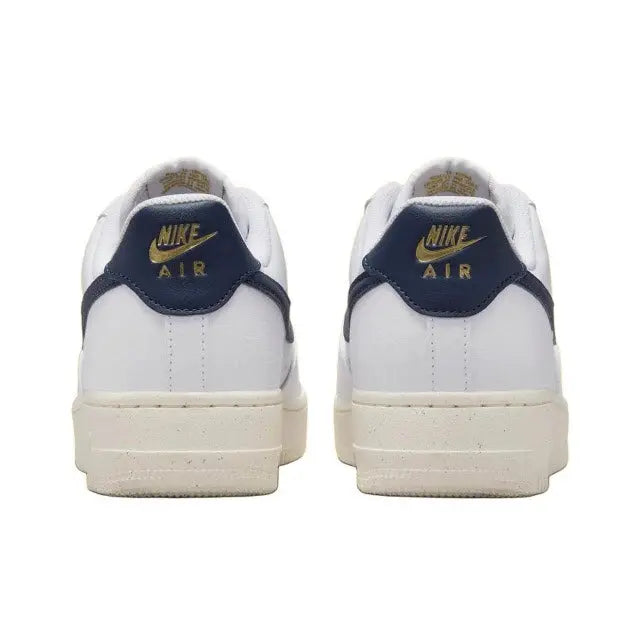 Nike Air Force 1 low-top sneakers with navy heel tab, gold Air logo, and white uppers