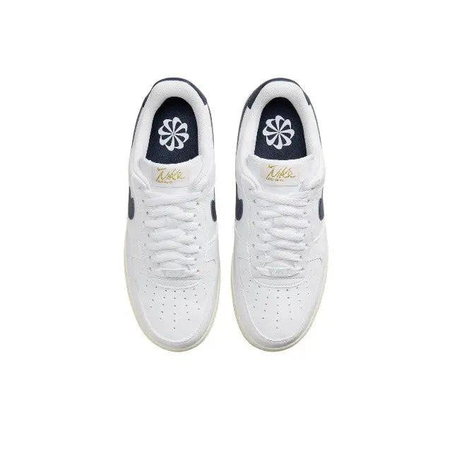 Nike Air Force 1 low-top sneakers pair, white laces with navy tongue and gold heel mark