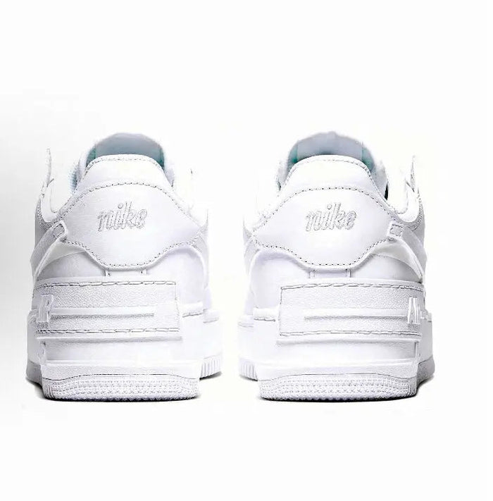 White low-top sneaker with rear heel tabs and Nike logo on heel, lace-up