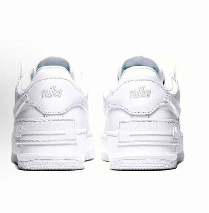 White low-top sneaker with rear heel tabs and Nike logo on heel, lace-up