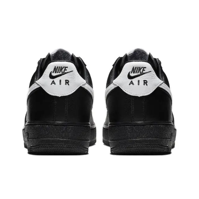 Black low-top sneakers with white heel label and rear padding