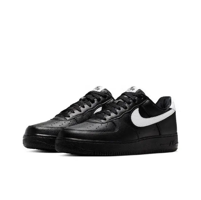 Black low-top sneakers with white swoosh panels and lace-up vamp