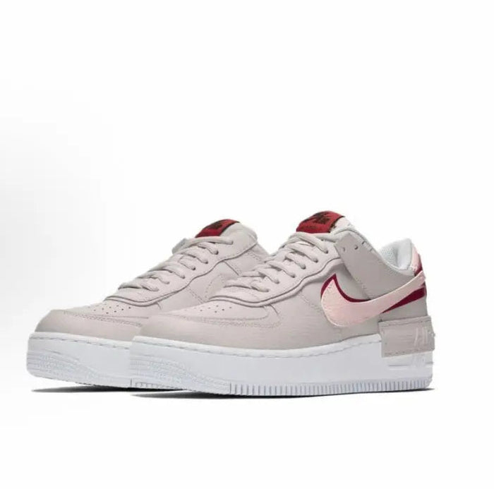 Nike low-top sneakers, light gray leather with red swoosh and pink collar accents