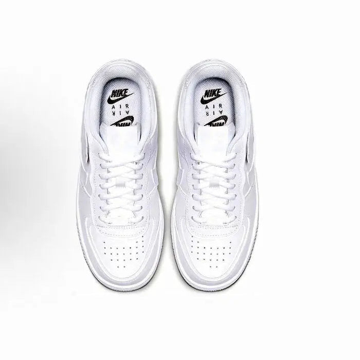 Pair of white low-top sneakers with lace-up eyelets and Nike Air tongue label