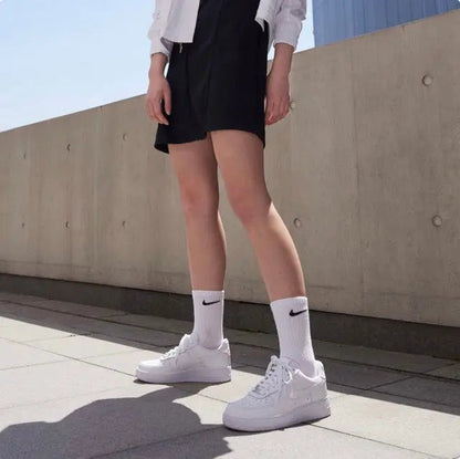 Person wearing white Nike Air Force 1 low sneakers with white crew socks