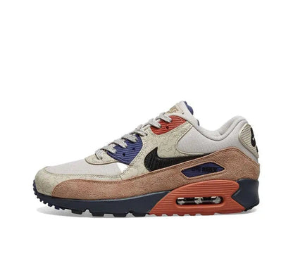 Nike Air Max 90 sneakers: cream upper, navy accents, brown mudguard, orange air sole