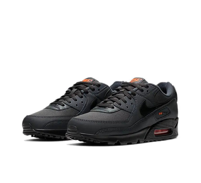 Nike Air Max 90 sneakers, pair view, dark charcoal black with orange heel details and Air unit