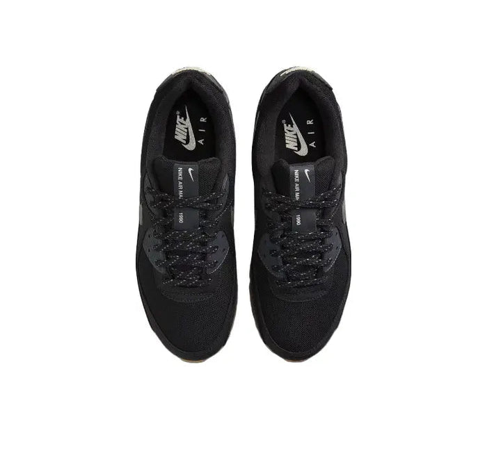 Nike Air Max 90 sneakers showing black uppers and lace eyelets