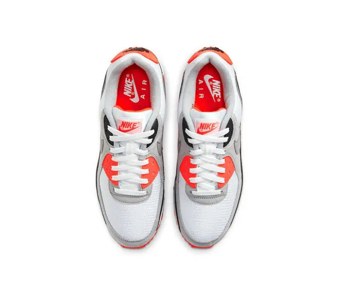 Air Max 90 shoes with white uppers, red lace stays, and “AIR” branding at tongue