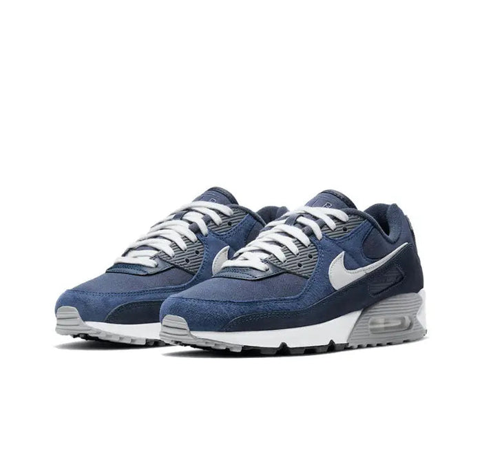 Low-top sneakers pair in dark blue with white swoosh and cushioned Air Max sole