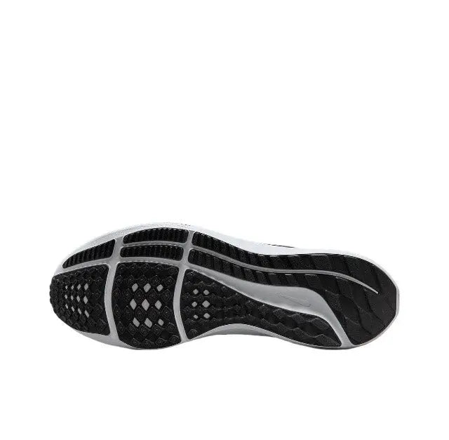 Outsole view of white and black running shoe with textured tread and flex grooves