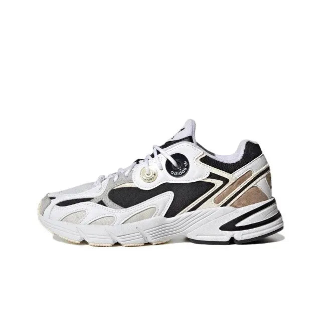 White and black lace-up sneakers with cream accents and chunky striped sole