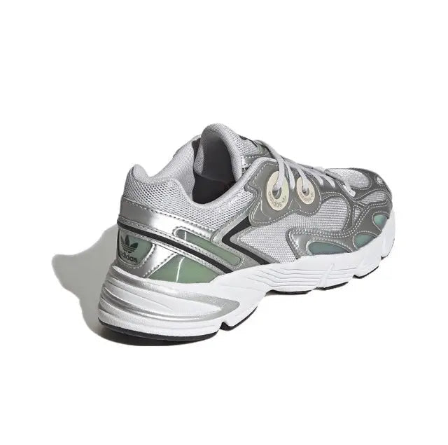 Low-top silver athletic sneaker, side view with molded stripes and cushioned midsole.