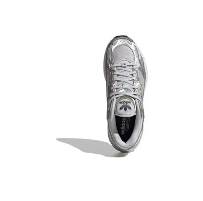 Low-top silver athletic sneaker with lace-up closure, side logo and black tongue label.