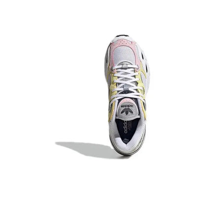 Adidas Astir sneaker, top view; white upper with yellow and pink accent details.