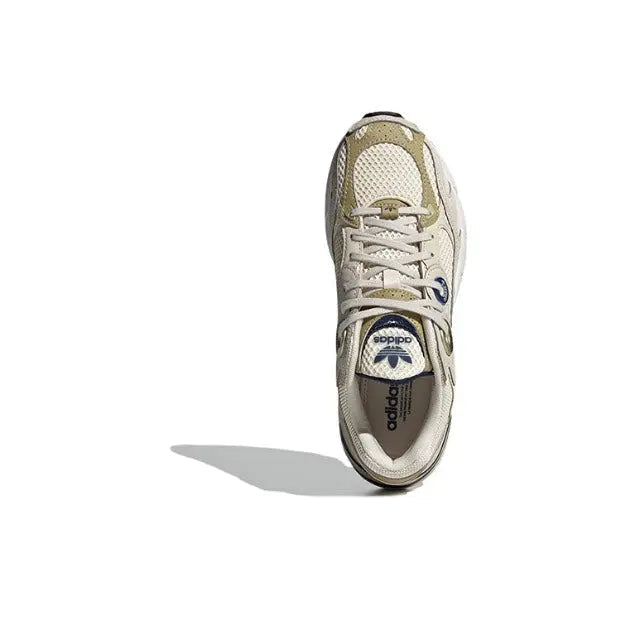 Lace-up sneaker side view in cream with light-gold overlays, blue eyelets, white midsole