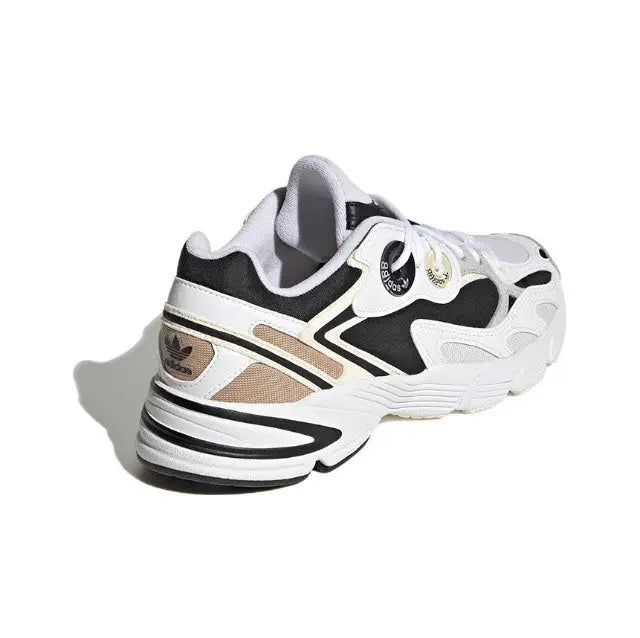 White and black lace-up sneakers with tan stripe accents and ribbed midsole