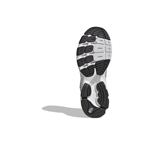 Shoe outsole of silver low-top athletic sneaker with black and white tread pattern.