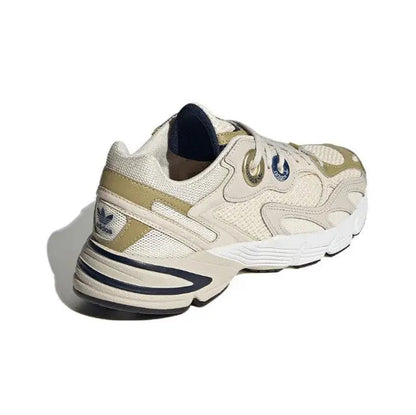 Cream lace-up sneaker with light-gold panels and navy collar lining, chunky striped sole