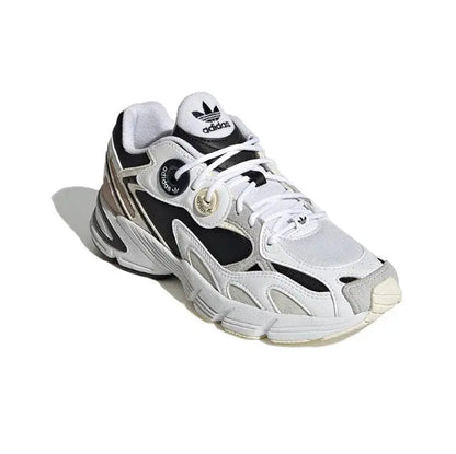 White lace-up sneakers with black panels, tan stripes, and Adidas heel branding