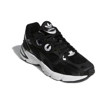 Black low-top Adidas sneakers with white accents, lace-up front, and logo details
