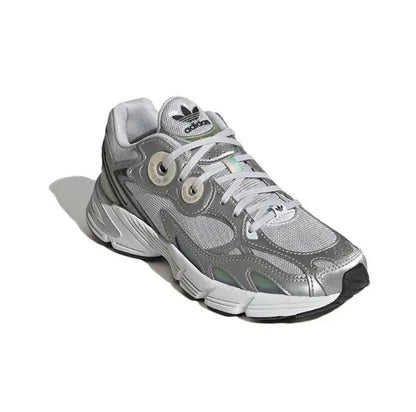 Low-top silver athletic sneaker with green line details, lace-up front and chunky sole.