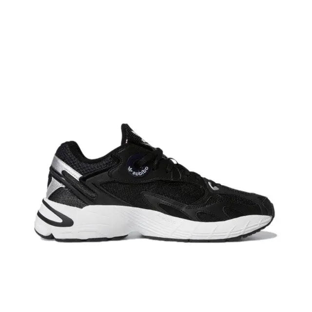 Black low-top sneakers side view with white midsole stripes and black textured upper