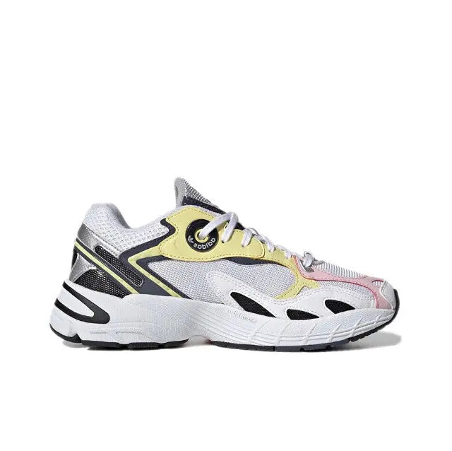 Adidas Astir sneaker, side view; white upper with black trim, yellow collar patch.