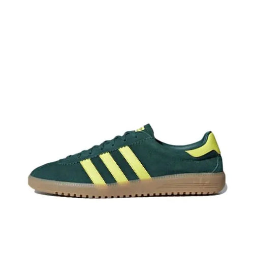 Low-top sneakers in dark green with yellow three-stripe accents and gum sole