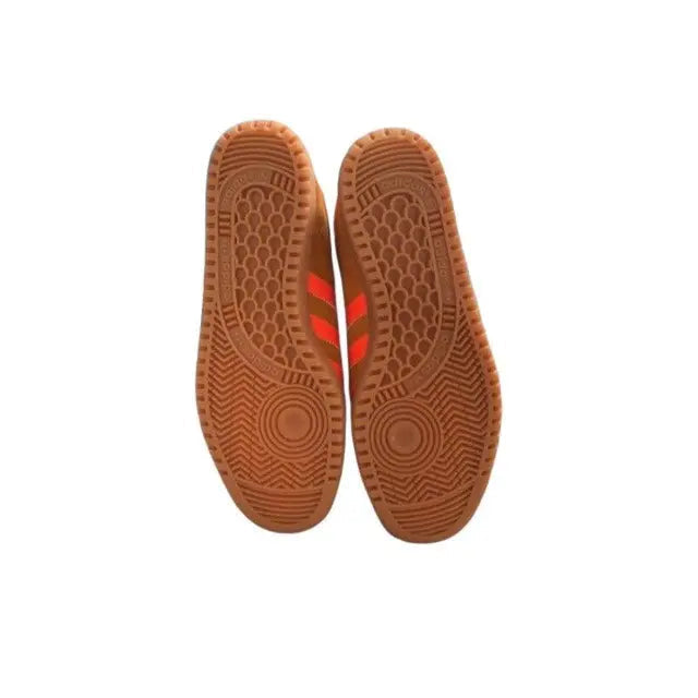 Shoe soles in textured gum brown with circular tread and pink stripe on side