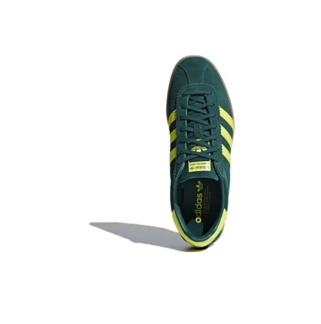 Low-top sneakers dark green with yellow heel stripes and lace-up front