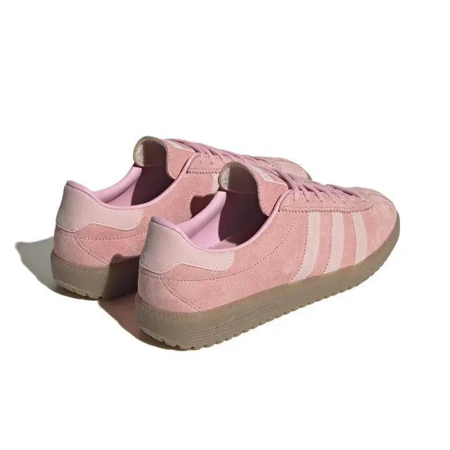 Pink low-top sneakers with heel tab and lace-up back view, gum sole