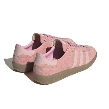 Pink low-top sneakers with heel tab and lace-up back view, gum sole