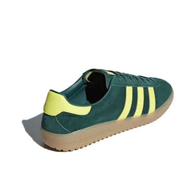 Low-top sneakers dark green with yellow sockliner and three stripes; gum sole