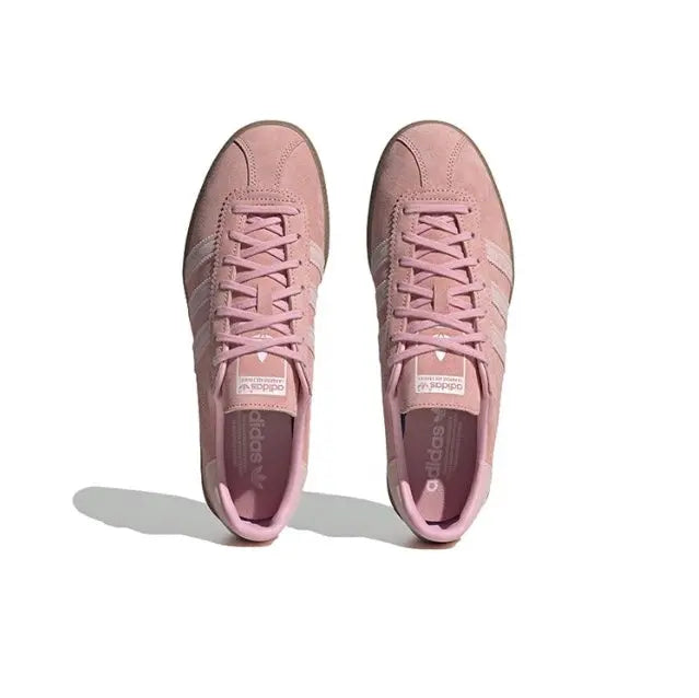 Pink lace-up sneakers with tongue label and three-stripe side panels, gum sole