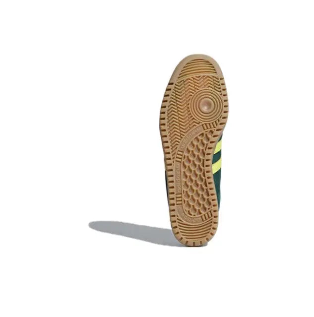 Outsole and heel view of dark green low-top sneakers with yellow stripe detailing