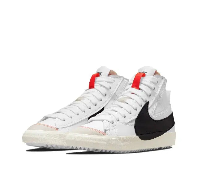 White high-top Nike Blazer sneaker pair with black swoosh and red strap