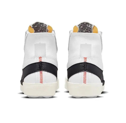 White and black Nike Blazer sneakers with red heel stitch detail