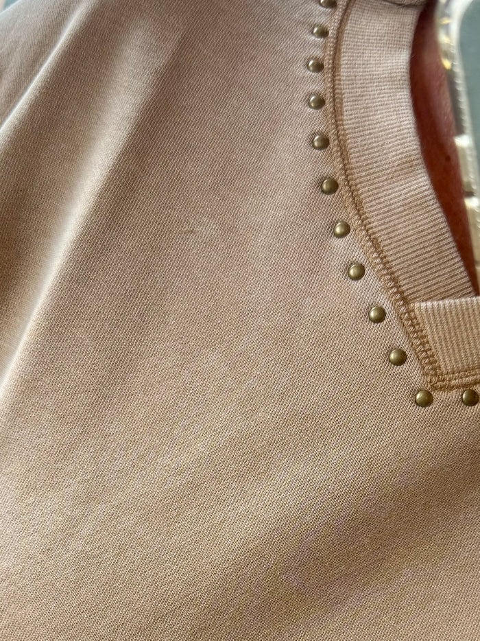Beige sweatshirt neckline with small gold button studs and ribbed trim
