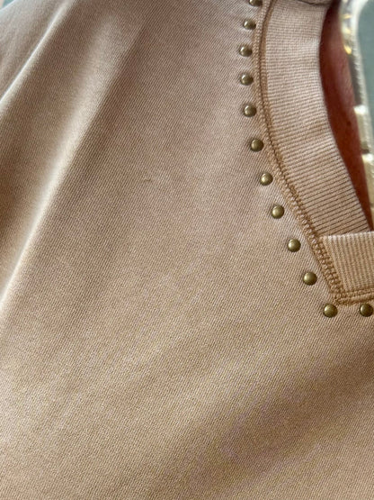Beige sweatshirt neckline with small gold button studs and ribbed trim